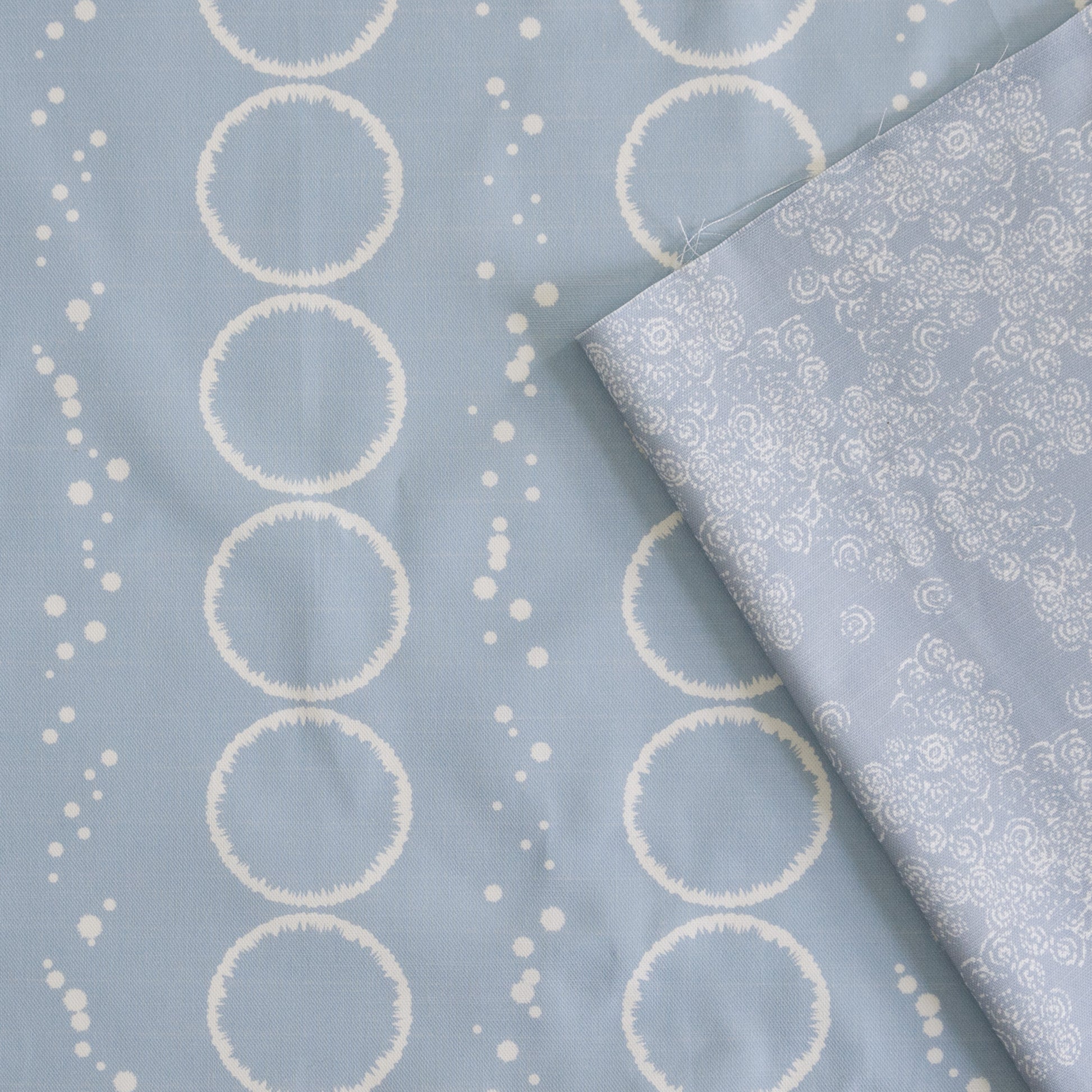 Splash Design in light blue grey printed onto white cotton linen for cushions curtains light upholstery and blinds  shown with Curls design in blue grey