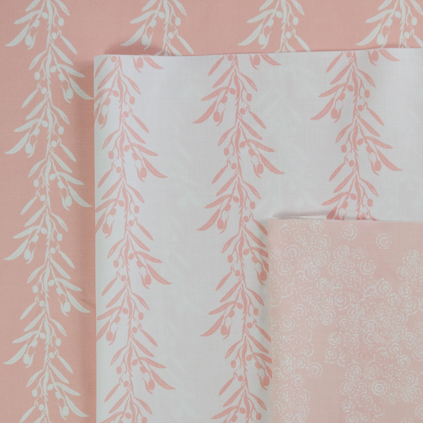 Set of fabric swatches with floral patterns on a pink background