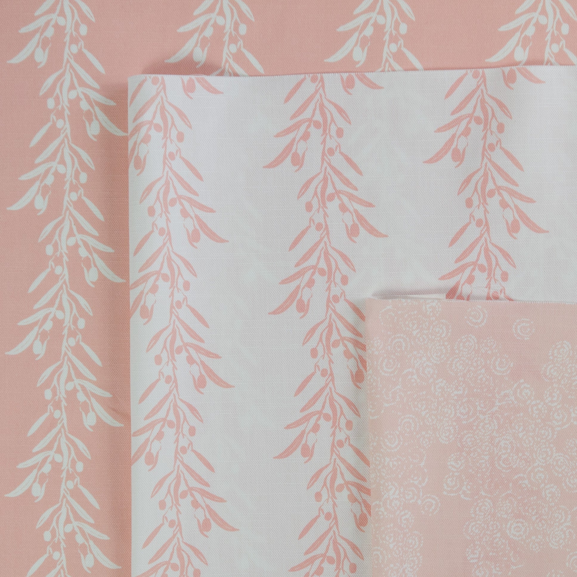 Set of fabric swatches with floral patterns on a pink background